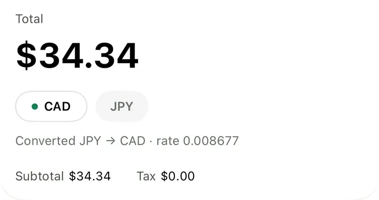 A receipt from a shop in Japan converted from yen, showing a $34.34 total, a currency toggle, and the exchange rate used